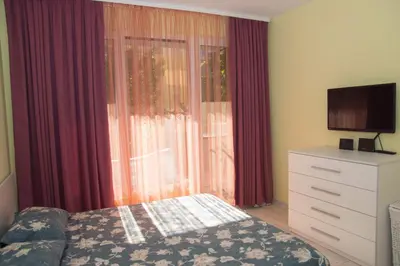 a bedroom with a bed and a dresser with a television at Луксозен апартамент Свети Влас Вила Аристо in Sveti Vlas
