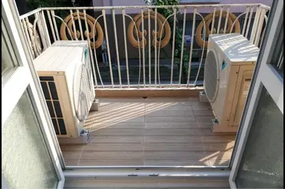 a balcony with a grill and chairs on a porch at Top Center 4-Bedroom Apartment in Varna City