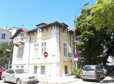 a yellow and white building with cars parked in front of it at Top Center 4-Bedroom Apartment in Varna City