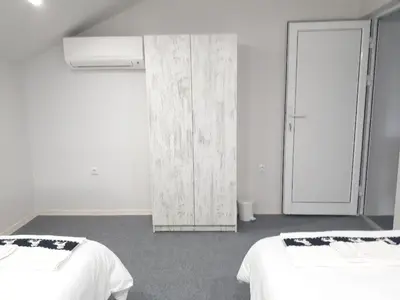 a white room with two beds and a closet at Top Center 4-Bedroom Apartment in Varna City