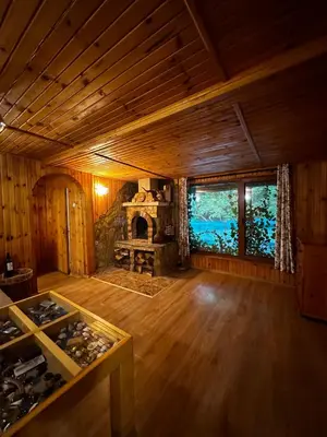 a large room with a stone fireplace in a cabin at “River Romance” Villa in Kamchia