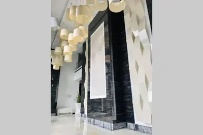 a hallway with black and white walls and chandeliers at Luxury Apartment Azure Coast Panorama in Burgas City