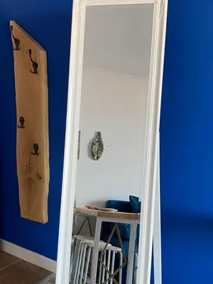 a mirror in a room with a blue wall at Свети Зосим in Sozopol