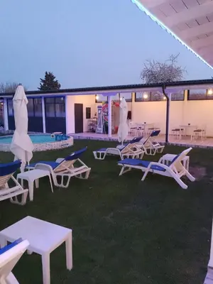 a group of lawn chairs and umbrellas in a yard at Weißer Schwan Белият лебед in Shkorpilovtsi