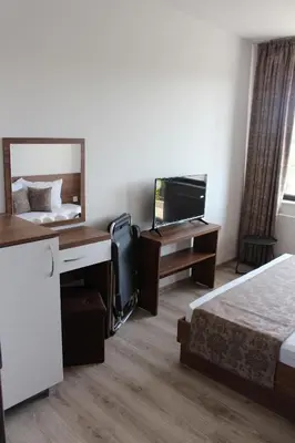a hotel room with a bed and a mirror at Weißer Schwan Белият лебед in Shkorpilovtsi