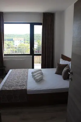a bedroom with a large bed with towels on it at Weißer Schwan Белият лебед in Shkorpilovtsi