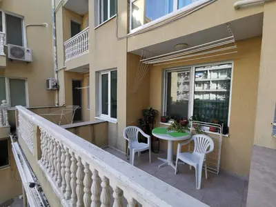 a balcony with a table and chairs on a building at Нашето място in Pomorie