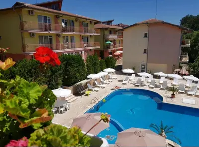 a hotel with a swimming pool and chairs and umbrellas at Курортно студио in Sunny Beach