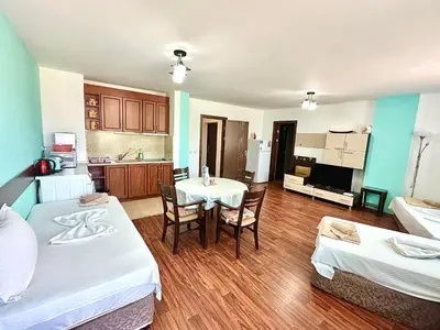 a kitchen with two beds and a table in a room at Апартаменти Зафи in Sozopol