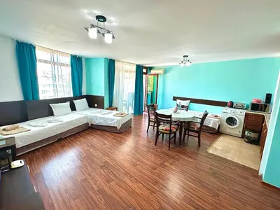 a living room with a bed and a table at Апартаменти Зафи in Sozopol