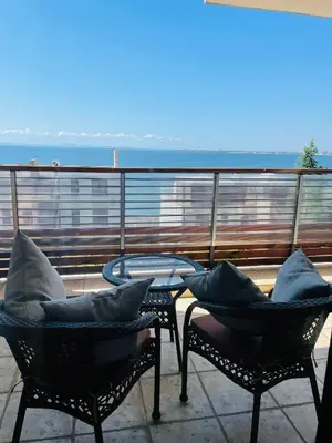 a balcony with two chairs and a table with pillows at Dolce Vita sea view apartment in Sveti Vlas