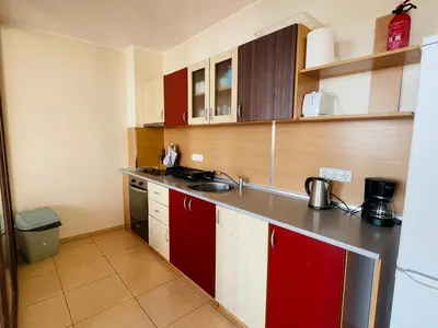 a small kitchen with red cabinets and a sink at Dolce Vita sea view apartment in Sveti Vlas