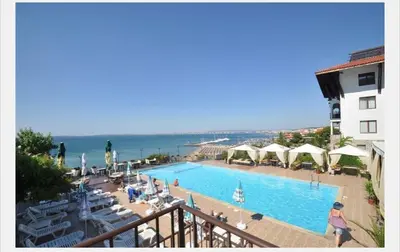 a view of a swimming pool with umbrellas and the ocean at Dolce Vita sea view apartment in Sveti Vlas