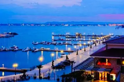 a marina at night with boats in the water at Dolce Vita sea view apartment in Sveti Vlas