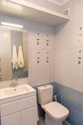 a bathroom with a white toilet and a sink at Апартамент в жълто in Burgas City