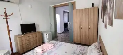 a bedroom with a bed and a tv on a dresser at Къща за гости ЕЛИ in Primorsko
