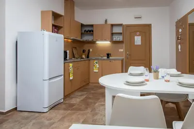 a kitchen with a white refrigerator and a table and chairs at Stylish flat in the TOP centre of Sunny Beach by Flаt Manаger in Sunny Beach