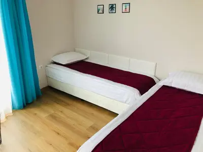 a bedroom with two beds and blue curtains at Colors Boutique in Obzor