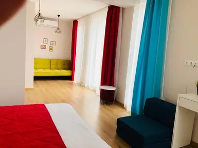 a bedroom with colorful curtains and a bed and a couch at Colors Boutique in Obzor
