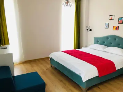 a bedroom with a blue bed with a red blanket at Colors Boutique in Obzor