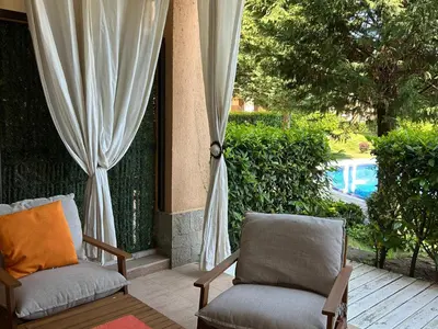 two chairs on a porch with a view of a pool at Sozopoli Hills Apartment A6 in Sozopol