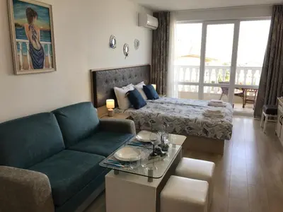 a living room with a bed and a couch at Студио Сънрайз А28, Лозенец in Lozenets