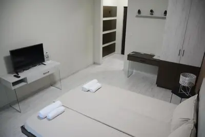 a white living room with a tv and a couch at Стаи за гости Гебедже in Beloslav