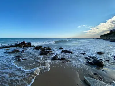 a beach with rocks and the ocean on a sunny day at Sea View Panoramic Apartments, Fort Noks Crown Club in Sveti Vlas