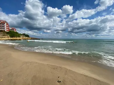 a beach with people in the water and buildings at Sea View Panoramic Apartments, Fort Noks Crown Club in Sveti Vlas