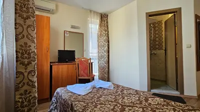 a hotel room with a bed and a mirror at Caprice Family Hotel in Varna City