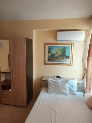 a bedroom with a white bed and a painting on the wall at Femili Hotel Diveda in Sveti Vlas