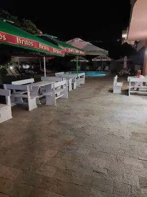 a group of white benches in front of a pool at Femili Hotel Diveda in Sveti Vlas