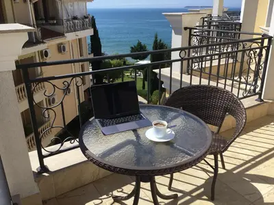 a laptop computer sitting on a table on a balcony at Horizon Katrina Apartments - Sea line & Beach Access in Sveti Vlas