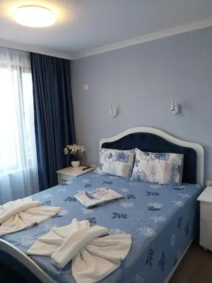 a bedroom with a blue bed with towels on it at Ravda on the Beach in Ravda