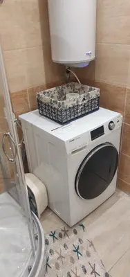 a washing machine with a box on top of it in a bathroom at Ravda on the Beach in Ravda