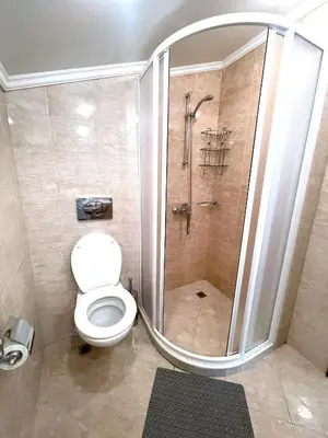 a bathroom with a shower with a toilet and a sink at Santa Marina resort Sozopol - penthouse with amazing sea view in Sozopol