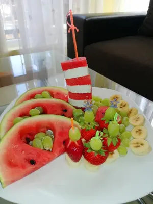 a cake with fruit and a candle on a table at House Apartments Black sea Hotel in Obzor