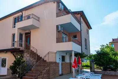 a building with stairs and tables and umbrellas at House Apartments Black sea Hotel in Obzor