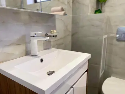 a bathroom with a white sink and a shower at Sozopol Dreams apartman 42 in Sozopol