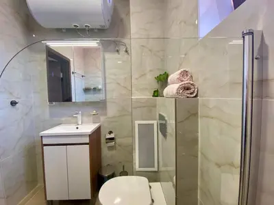 a bathroom with a shower and a toilet and a sink at Sozopol Dreams apartman 42 in Sozopol