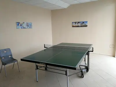 a ping pong table in a room with a chair at Wonderful family villa with sea view in Byala
