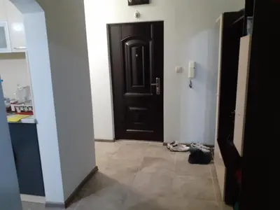 a hallway with a black door and shoes on the floor at Varna beach in Varna City