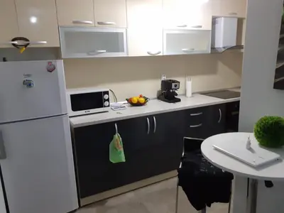 a kitchen with a white refrigerator and a table at Varna beach in Varna City