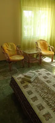 a living room with two chairs and a table at гостевой дом у Снежаны in Provadiya