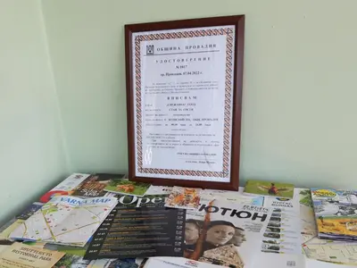 a picture frame sitting on top of a table with magazines at гостевой дом у Снежаны in Provadiya