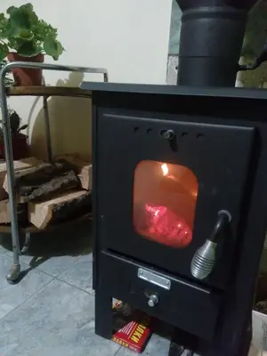 a black stove with a fire in it at гостевой дом у Снежаны in Provadiya
