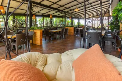 a couch in a restaurant with tables and chairs at Hotel Julia in Sveti Vlas