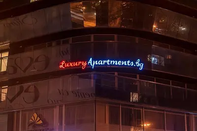 a neon sign on the side of a building at Luxury Apartments Burgas in Burgas City
