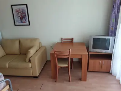 a living room with a table and a couch and a television at FORT NOKS NESSEBAR B2-203 Private Studio Sunny Beach in Sunny Beach