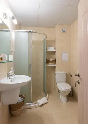 a bathroom with a shower and a toilet and a sink at Aquamarine in Pomorie